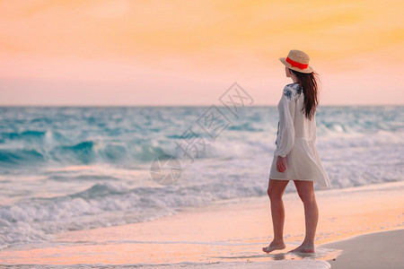 年轻美丽的女士在日落时海滩上放松女人躺在海滩上享受暑假看着海的夏天假期闲暇模型健康图片