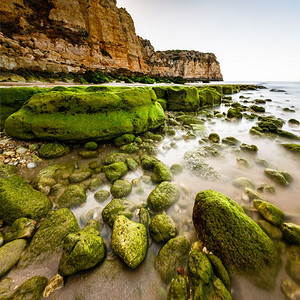 暮上午葡萄牙Algarve拉各斯PortodeMos海滩的岩石和克里夫绿色粉的图片