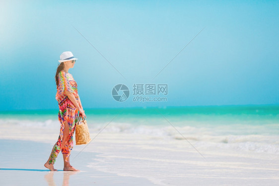 田园诗般的在海滩上穿绿裙子的年轻时尚女郎在海滩上穿着绿色衣服的年轻时装女郎在海滩上健康采取图片