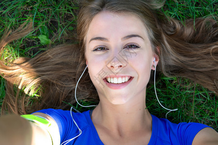 快乐的年轻一种美健身女孩在户外锻炼后休息时拍自照片图片
