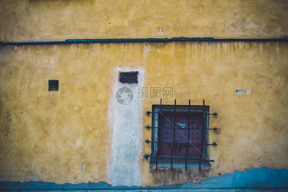 带网格的黄色长墙古老的粗糙窗户图片