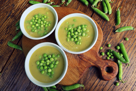 优质的新鲜豌豆汤种子和荚围绕选择焦点专注于汤中间的豌豆新鲜汤专注于中间的豌豆开胃菜图片