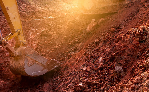 地球黄色的履带式反铲挖土的金属桶反铲在施工现场挖土掘机在泥上方机械挖掘车辆建筑业务图片