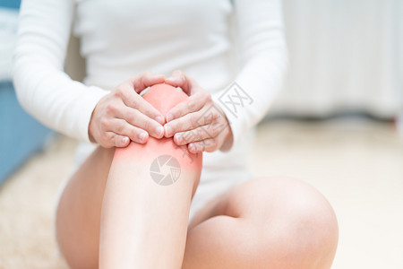 健康脊医手妇女坐着并抚摸膝盖痛腿部愈合疼伤害坐着且触脚的妇女痛苦保健和医药概念图片