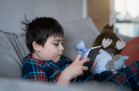 活动白种人带着笑脸的快乐孩子在平板上玩游戏乐和圣诞假日的朋友一起玩牌男孩穿着圣诞睡衣早上在家放松互联网图片