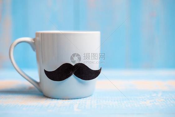关心国际的颜色早晨父亲国际男子日前列腺癌意识和世界症日概念在木桌背景上用黑胡子涂着的蓝咖啡杯图片