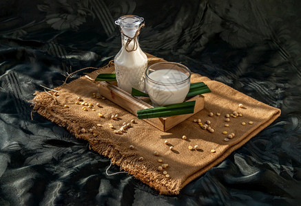 绿色产品玻璃一杯自制豆类牛奶和大装在木盘和蜂蜜中早上亮光照明的自制豆类奶粉和谷物大豆替代牛奶概念选择焦点复制空间图片
