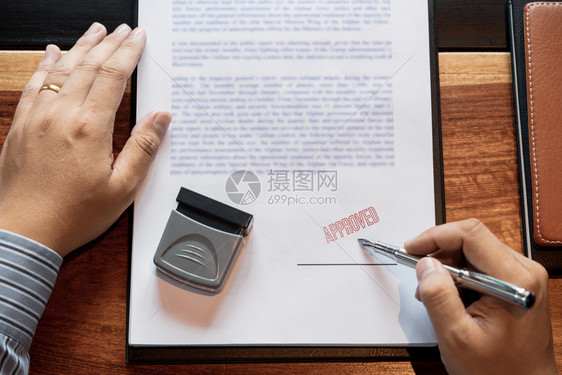 质量最好的在核准贷款文件协议律师亲手概念的印章后男子在证书合同中签字或男高级商人在批准贷款文件协议书上加盖印章后象征图片
