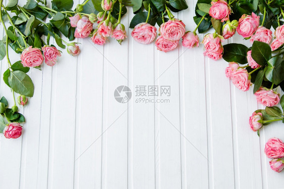 在明亮的桌子上用美丽粉红玫瑰和叶子组成的文字位置在明亮的桌子上用美丽粉红玫瑰和叶子组成文字新鲜的植物群假期图片