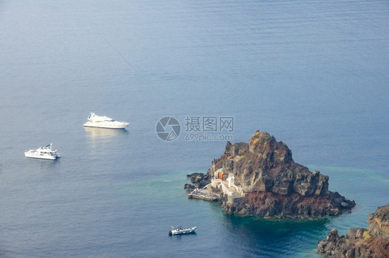 多岩石的从上方对一个小岩礁岛的景象上有一座码头两艘游艇和一船停靠在小洛基岛附近的游艇和AnchodAnchored风景夏天图片