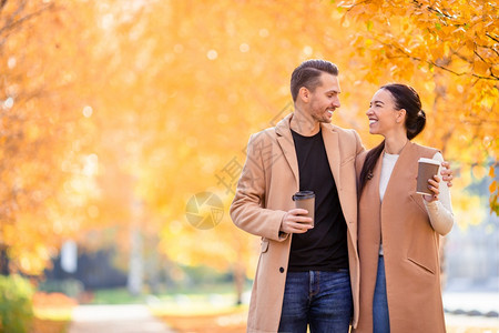 户外漫步女士快乐的一对夫妇在秋天公园走阳光明媚的秋天幸福家庭在秋天公园走图片