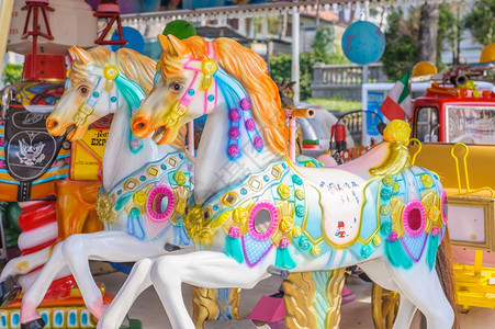 怀旧的儿童游览场两匹马骑在儿童游乐场的旋转木马上狂欢制的图片