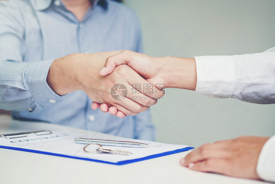 专业的销售代理商和客户握手签署协议合同保险房概念合伙买方图片