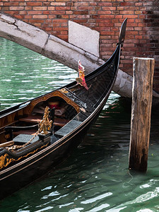运河外部的意大利威尼斯Gondolarsquos近距离靠的铁笔和古董桥巡航图片