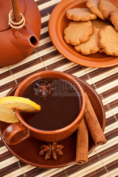 冬茶加肉桂和竹餐巾上的星葵香烘烤陶瓷制品照片图片