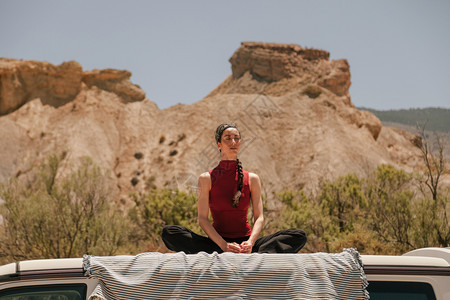 畅快女人在沙漠的一辆货车屋顶上做瑜伽女成人图片