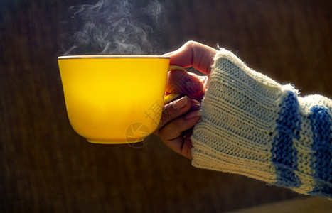 圣诞节休息空白的女人手握着黄杯咖啡热或茶冬天图片
