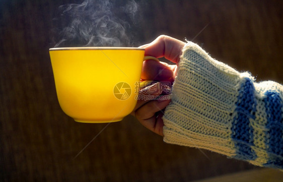 圣诞节休息空白的女人手握着黄杯咖啡热或茶冬天图片