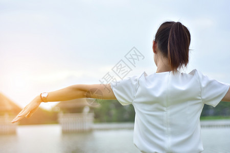 日落美丽的夏天妇女早上在市公园里站着图片