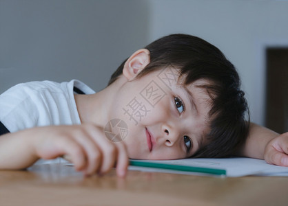 趴在桌子上学习的小男孩图片