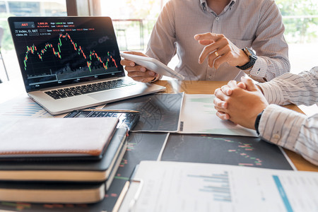 战略经理工作商人纪或贸易商团队谈论股票市场多台计算机屏幕上的反面对交易金融图表数据分析进行投资的金融图表数据分析投资者图片