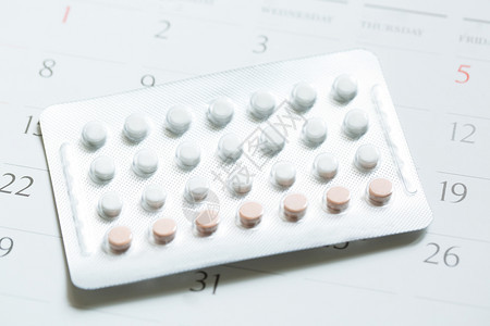 制药年轻的在列入日历的背景保健和医药护理日历期使用避孕药控制片生育控制概念图片