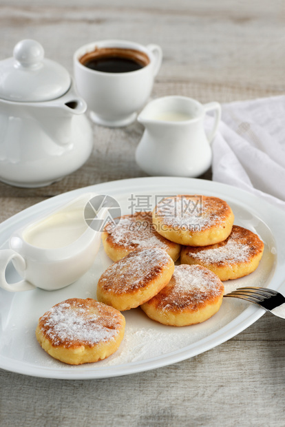 粉状食品一顿饭早餐芝士煎饼加酸奶油洒在白盘上加糖粉图片