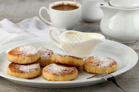 食物早餐芝士煎饼加酸奶油洒在白盘上加糖粉一种自助餐图片
