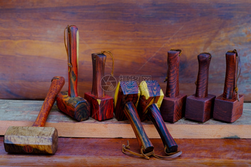 由泰国手工制作的玫瑰木具制成供匠在旧工作台讲习班上使用的一套小块木板锤棕色的乐器作坊图片