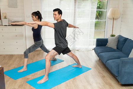 居家瑜伽锻炼的夫妇图片
