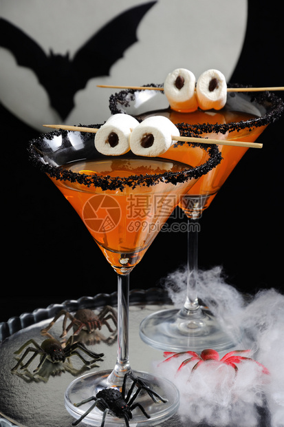 酒鸡尾为纪念万圣节在餐桌上戴着棉花糖眼珠的黑装饰柑橘玛蒂尼桌子图片