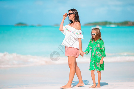 童年在海滩上的母亲和女儿家庭小女孩的肖像暑假母亲的幼女团结采取图片