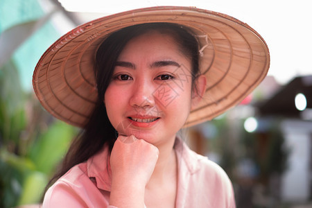 身戴越南草帽面带笑脸背景模糊的亚洲女肖像年轻美女孩旅行身体图片