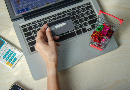 药片持信用卡和智能电话的亚洲女手握信用卡和智能电话供家庭网上购物营销沟通图片