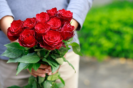 一位年轻男子在华伦人节给女友一盒玫瑰礼物情人节美丽的图片