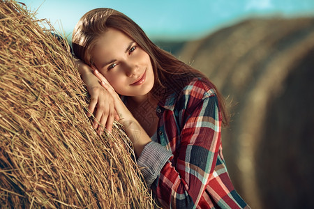 幸福阳光下干草堆旁的年轻女人肖像户外天空图片