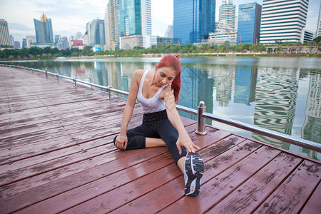 合身混女运动员在市公园伸展腿部肌肉的锻炼成人图片