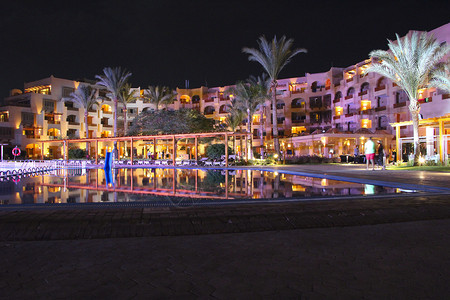 旅游美丽的热带度假酒店晚上倒映在游泳池的水中埃及度假胜地的期晚上酒店的灯光倒映在晚上的游泳池水中赫尔格达度假酒店的明亮灯光晚上度图片
