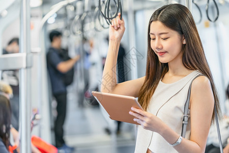 车站人们假期乘坐地铁火车技术平板机的亚洲青年女乘客在大城市japanesechinese朝韩生活方式和日常commuter及交通图片