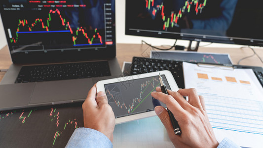 公司的银行营销工作商人经纪或贸易商团队谈论股票市场多台计算机屏幕上的反面对交易金融图表数据分析进行投资的金融图表数据分析图片