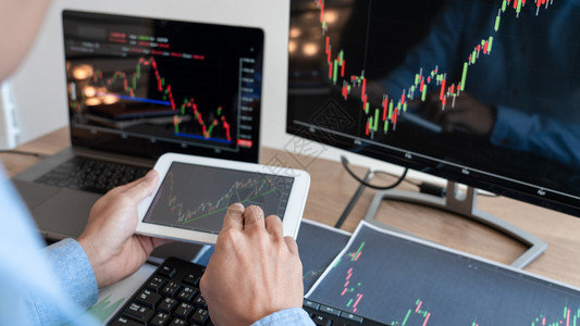 商业全球的交换工作商人经纪或贸易商团队谈论股票市场多台计算机屏幕上的反面对交易金融图表数据分析进行投资的金融图表数据分析图片