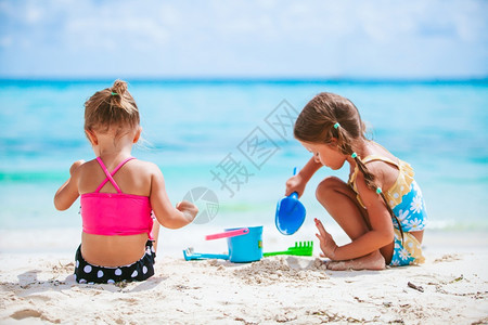 假期制造岛小女孩在热带海滩玩得开心一起沙堡两个快乐的小女孩在热带海滩玩得很开心图片