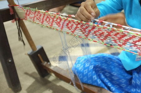 离开工艺手女人从泥米董事会脱铁丝网织泥米是一种物模式通过使用防水材料将棉线绑在想要的模式上在染色棉花之前图片