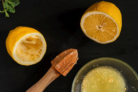 柠檬在黑木桌上半边用手工果汁机做柠檬美味的植物桌子图片