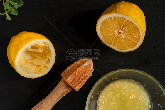 柠檬在黑木桌上半边用手工果汁机做柠檬美味的植物桌子图片