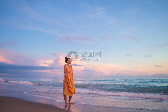 游客年轻美丽的女士在日落时海滩上放松女人躺在海滩上享受暑假看着海的夏天假期生活闲暇图片