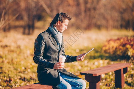 秋季公园里使用平板电脑的男性图片