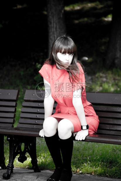 坐在公园桌旁的美容女木头肉欲红色的图片