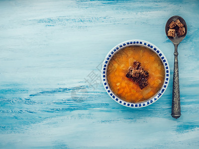 营养食物传统的一份有用和饮食的蔬菜汤配上旧匙和面包条放在蓝色破旧的反面柜台上一份有用和饮食的蔬菜汤配上旧匙和红锅图片