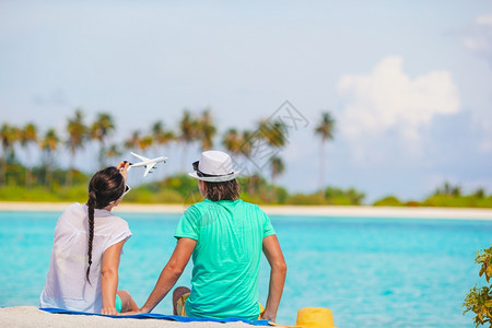 微笑两个家庭在沙滩上拍着一对幸福的情侣在沙滩上的太阳眼镜夏令英俊的图片